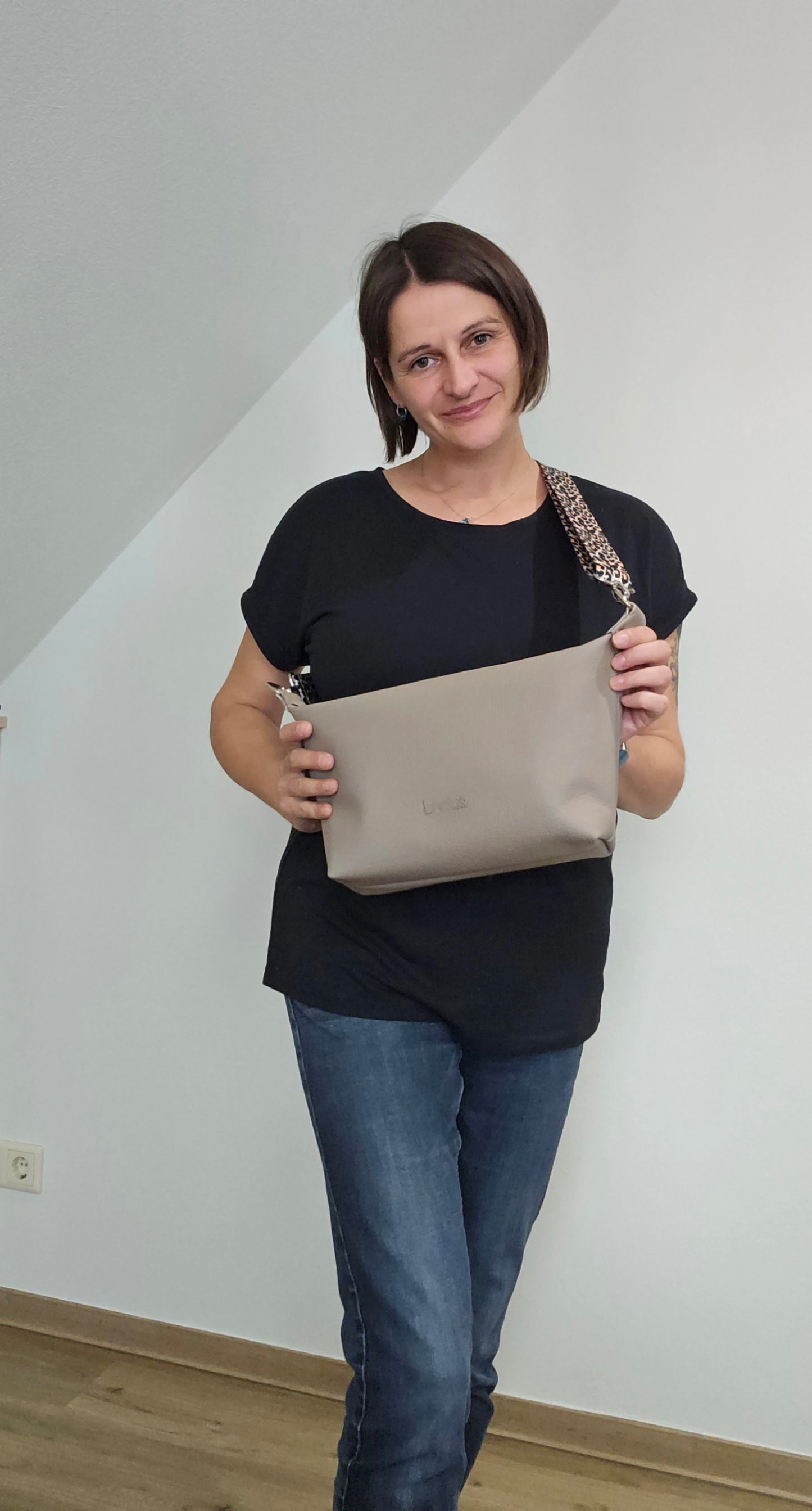 Ledertasche Petra, Cappuccino mit Leo, in der Hand von Designerin Michaela Lucius 
